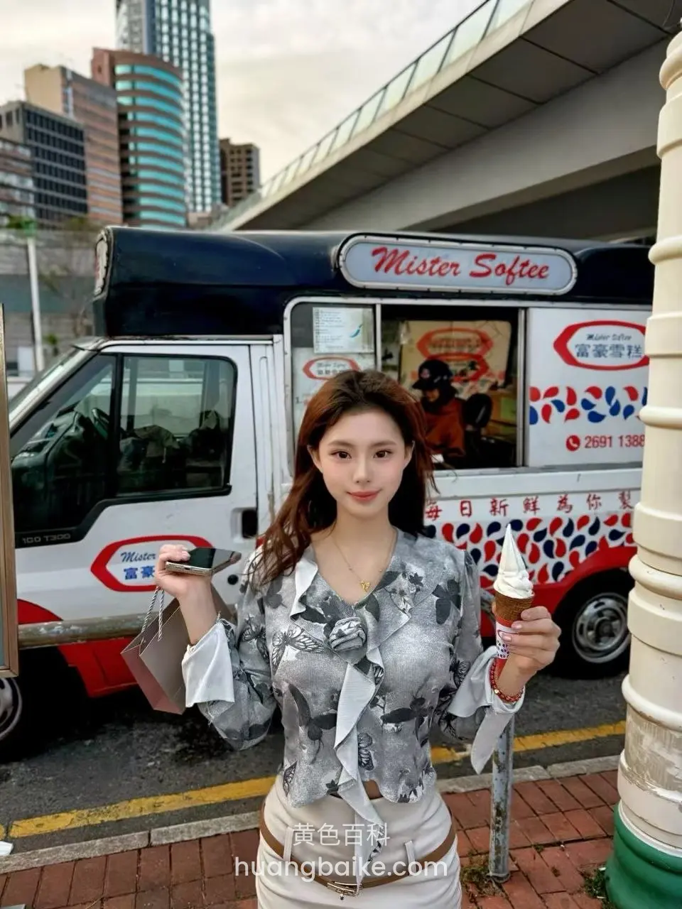 Mister Softee 冰淇淋车前，手持甜筒和手机