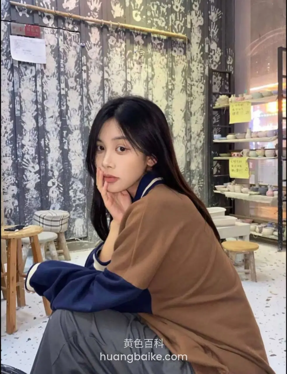 店内墙边蹲着，手托下巴看镜头
