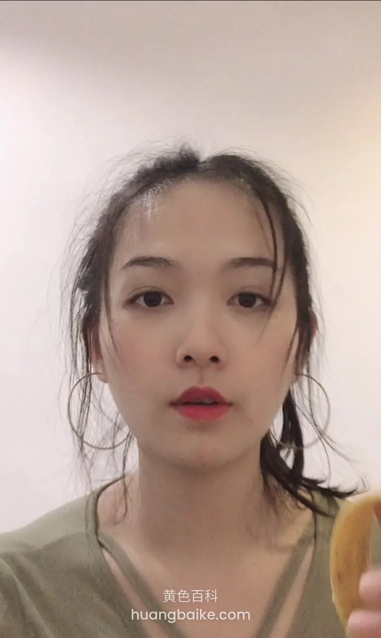 黑发女人手持香蕉面对镜头