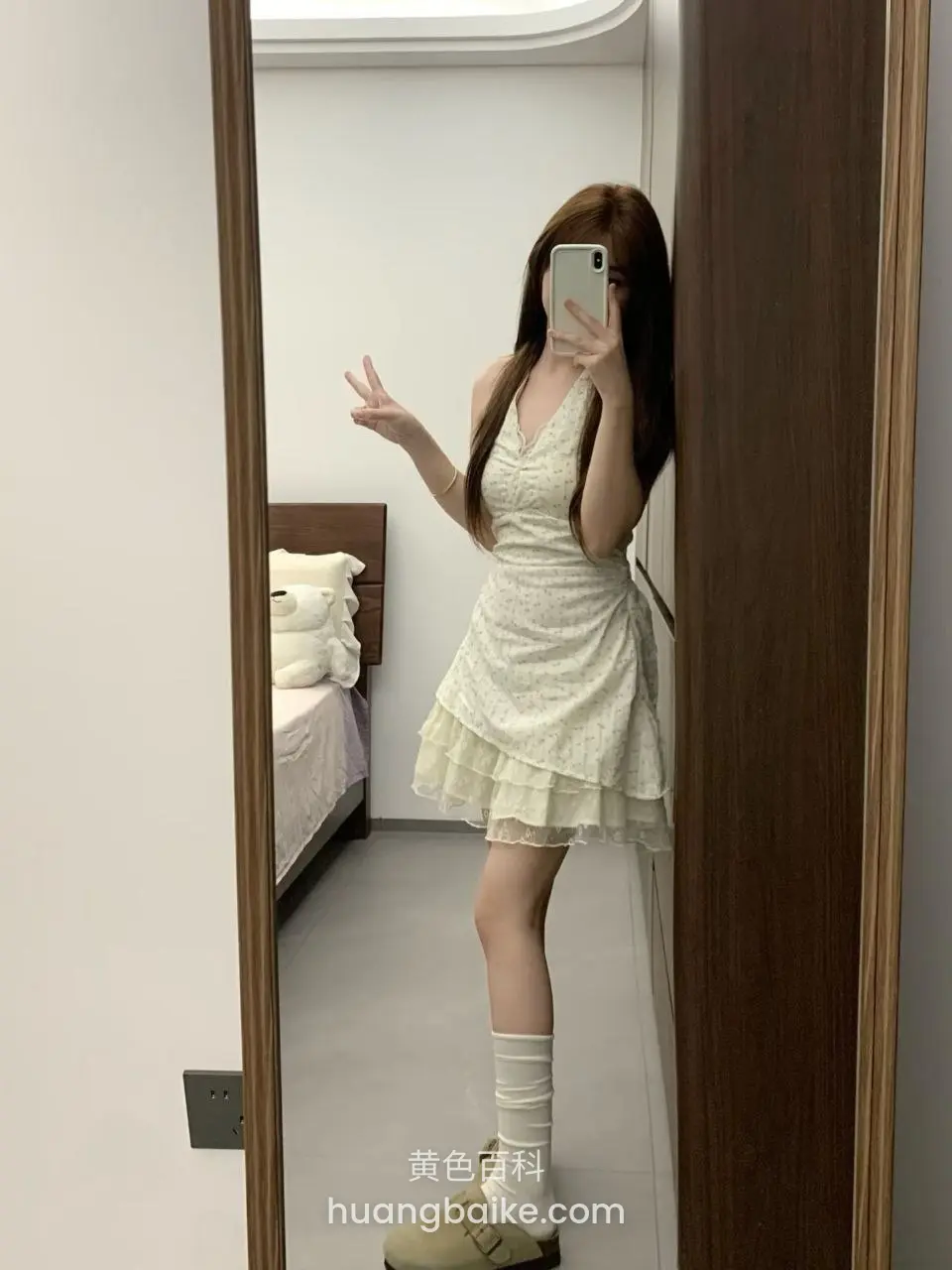 镜子前举手机自拍，另一手比耶