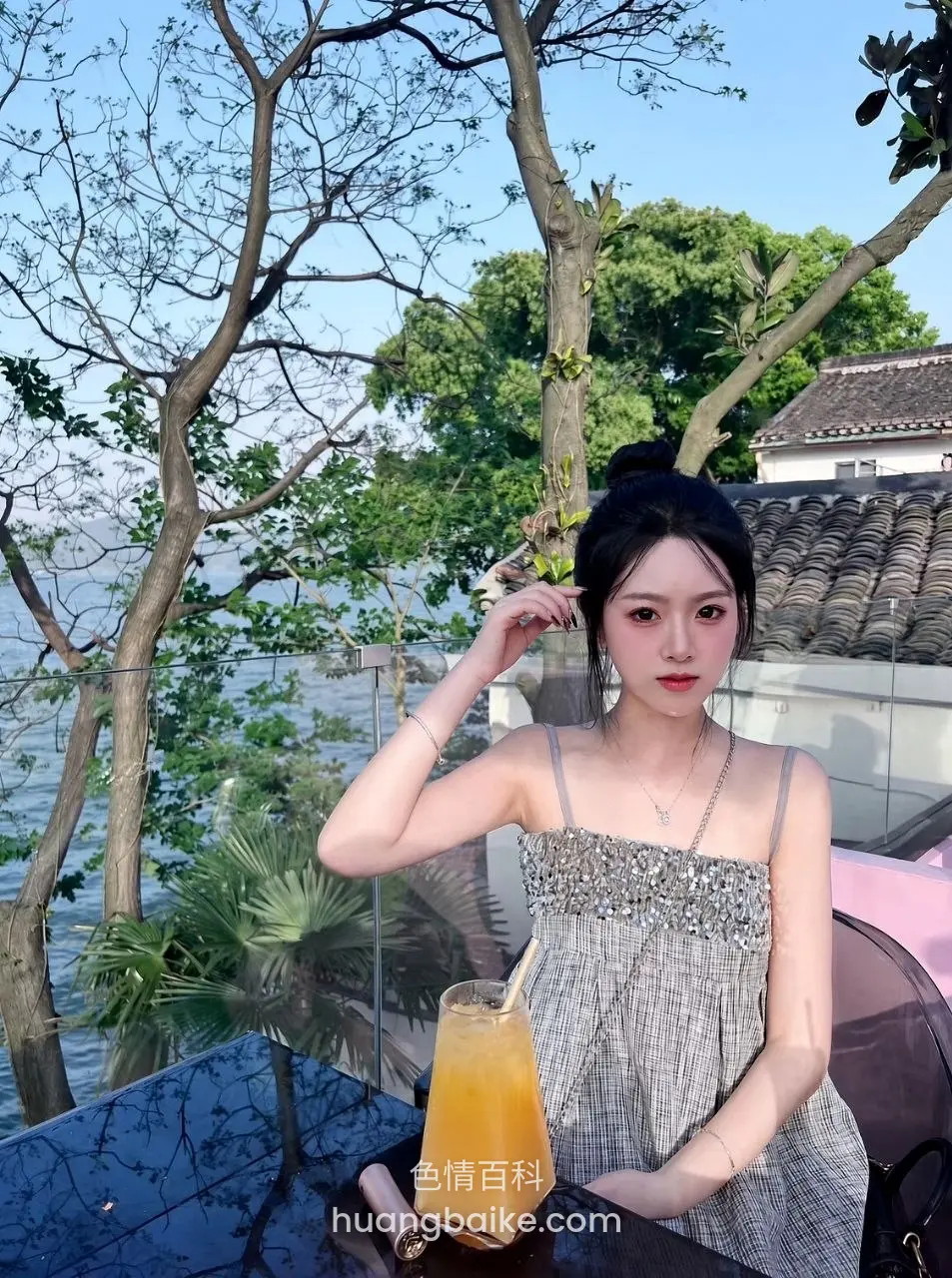 湖边树下橙汁桌上，手托头发