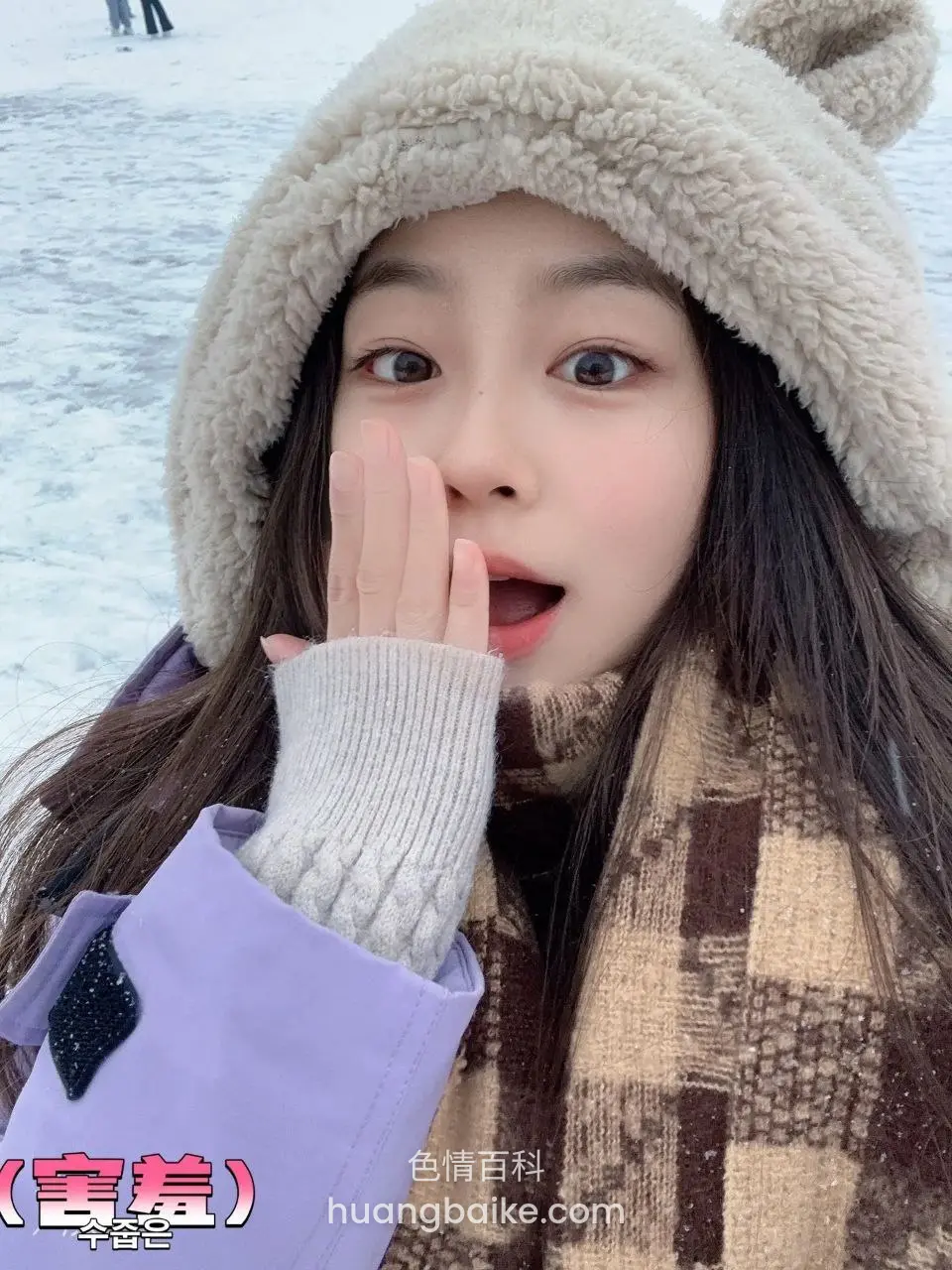 雪地戴熊帽捂嘴睁大眼看镜头