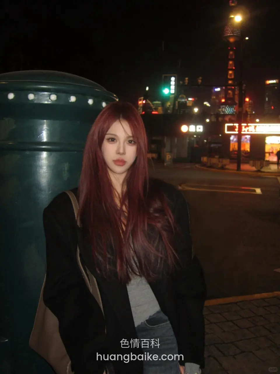 夜间路灯下站立，身后塔楼和商铺
