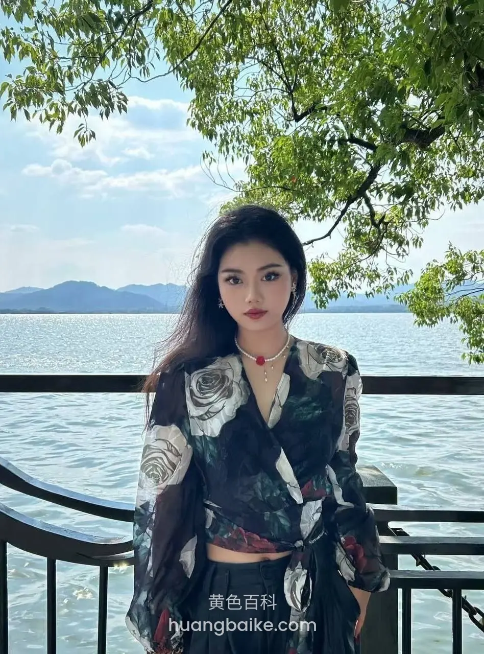 湖边栏杆前站立，身后是湖水和远山