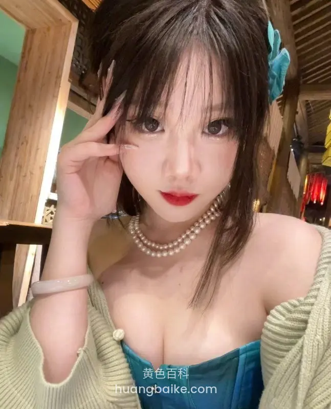 女生戴珍珠项链手比剪刀手