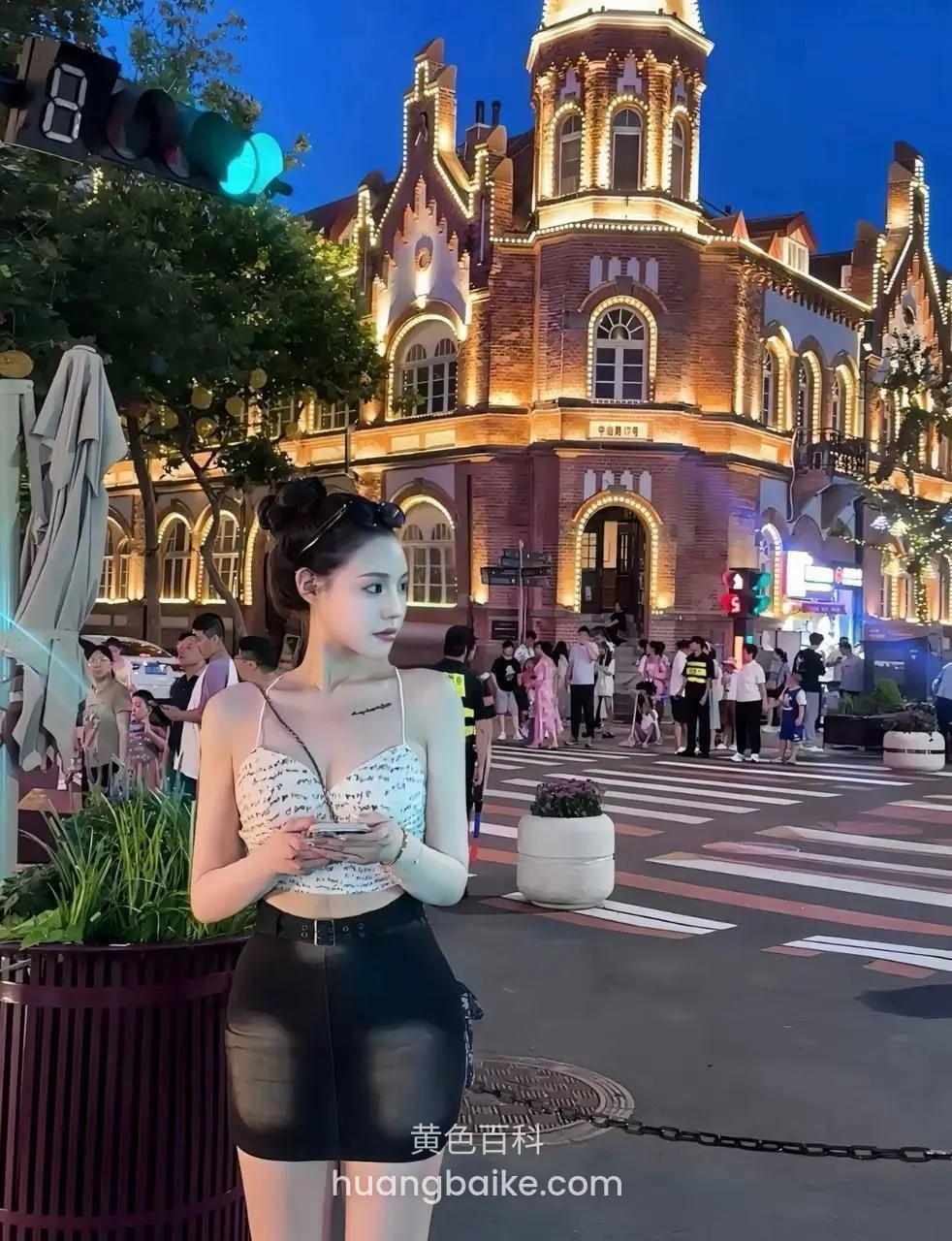 夜景建筑前十字路口拿着手机