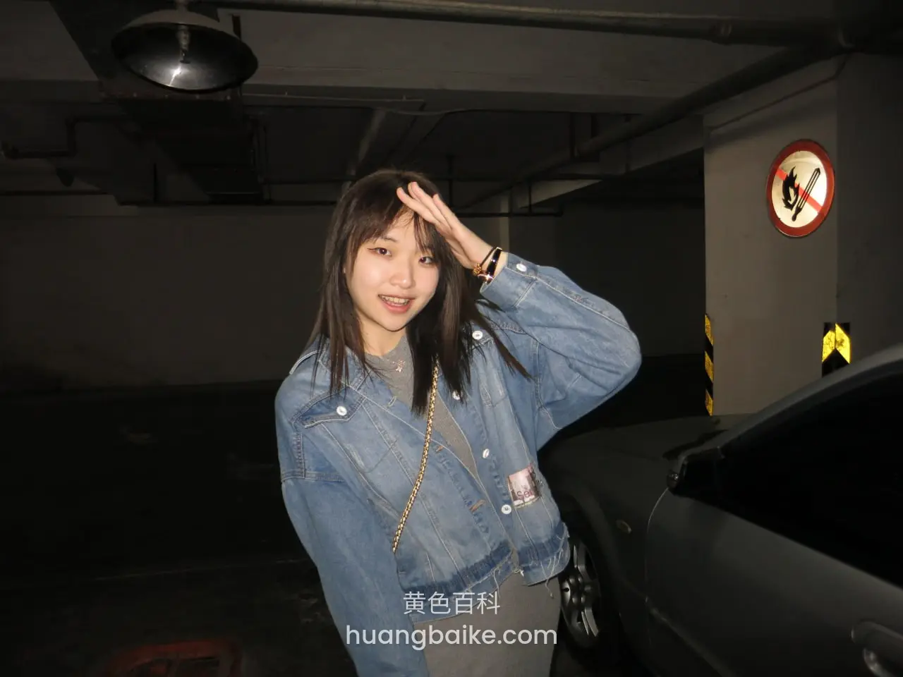 地下车库里手遮额头，身旁停着黑车