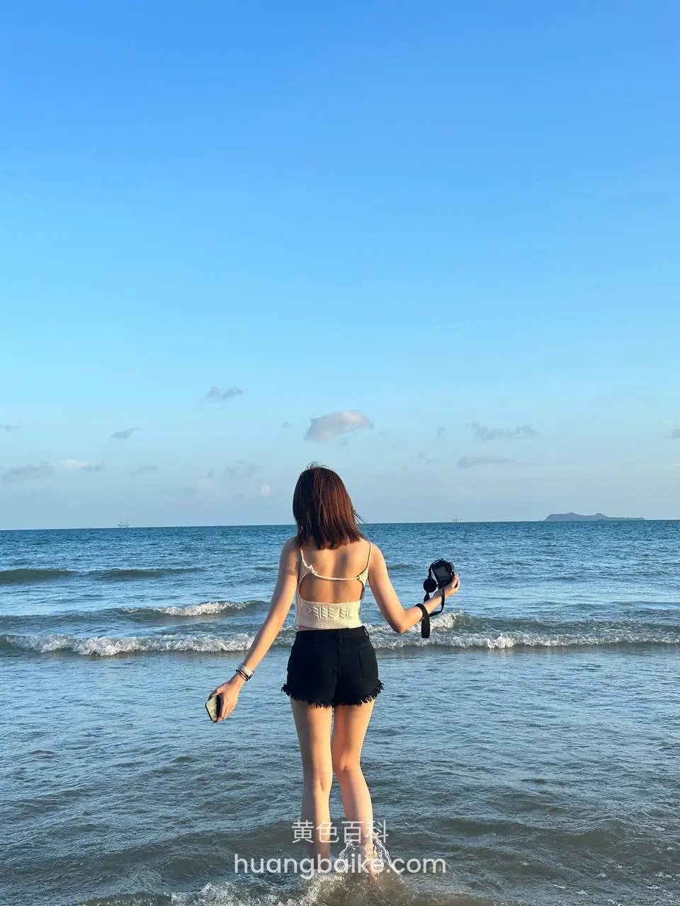 海边浅滩背对镜头，手持相机看海 12字