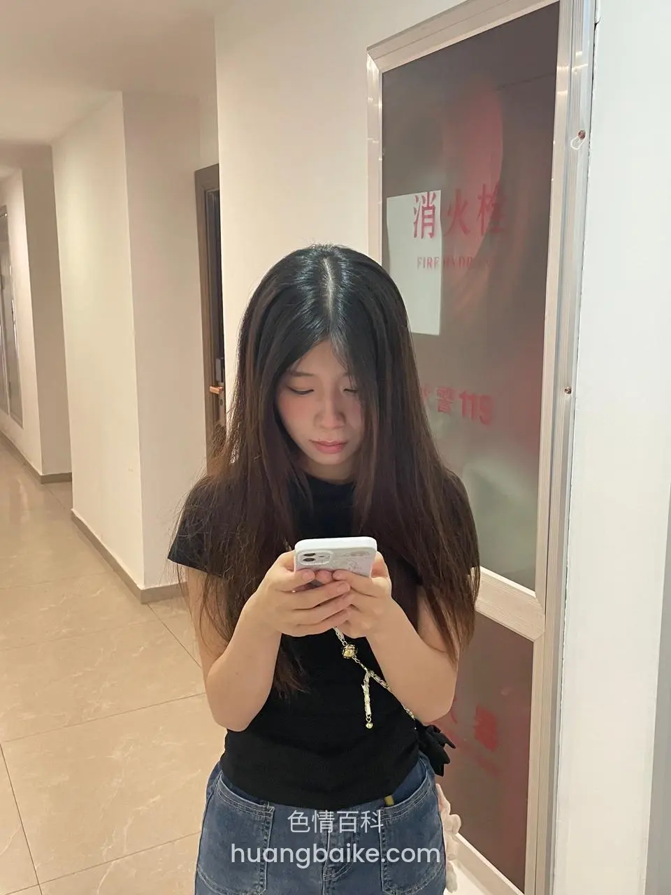 走廊里低头玩手机