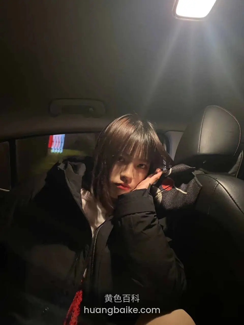 后排座椅上撑着脸看镜头，车顶灯打光