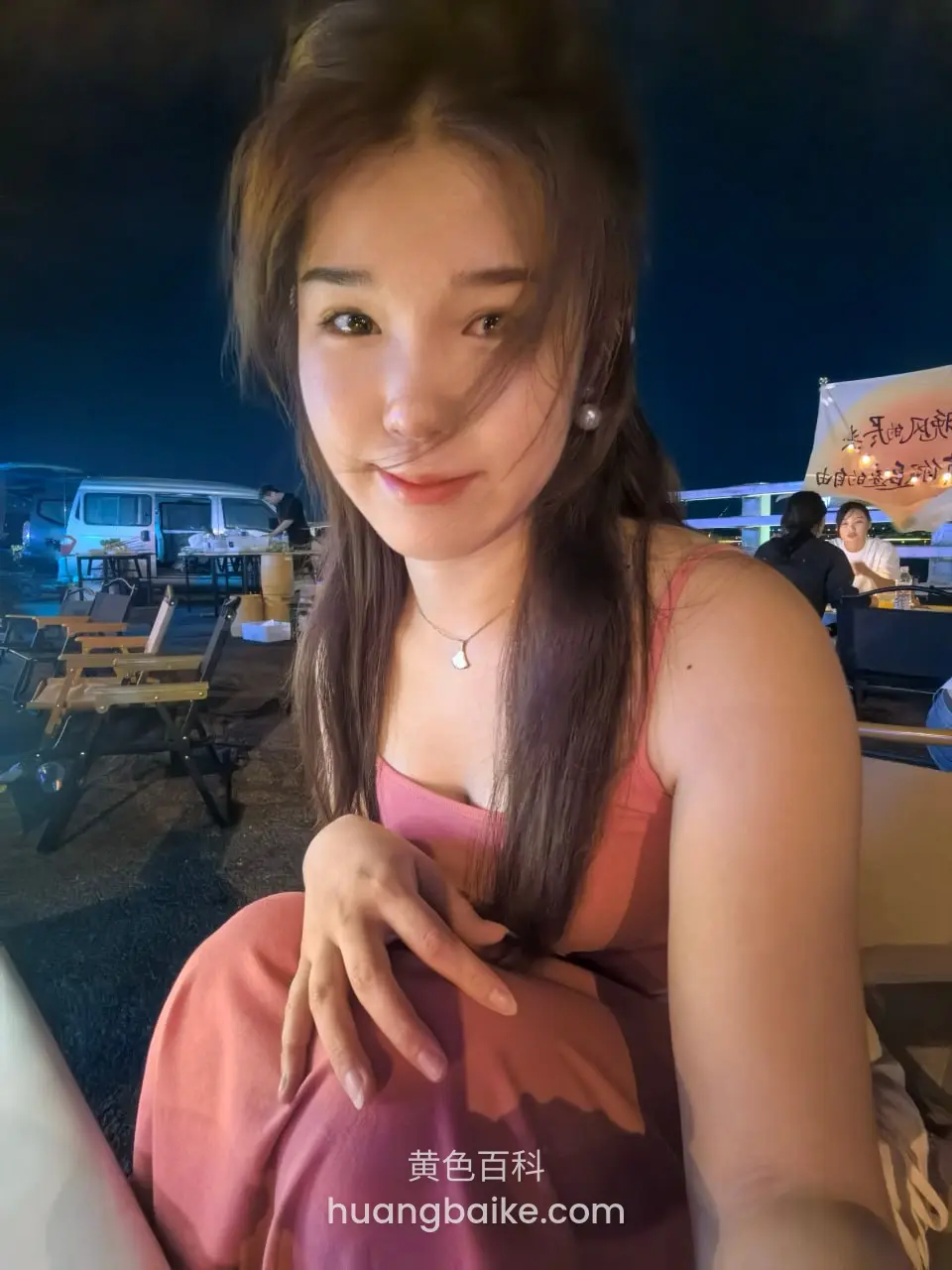 夜市摊位前低头玩头发
