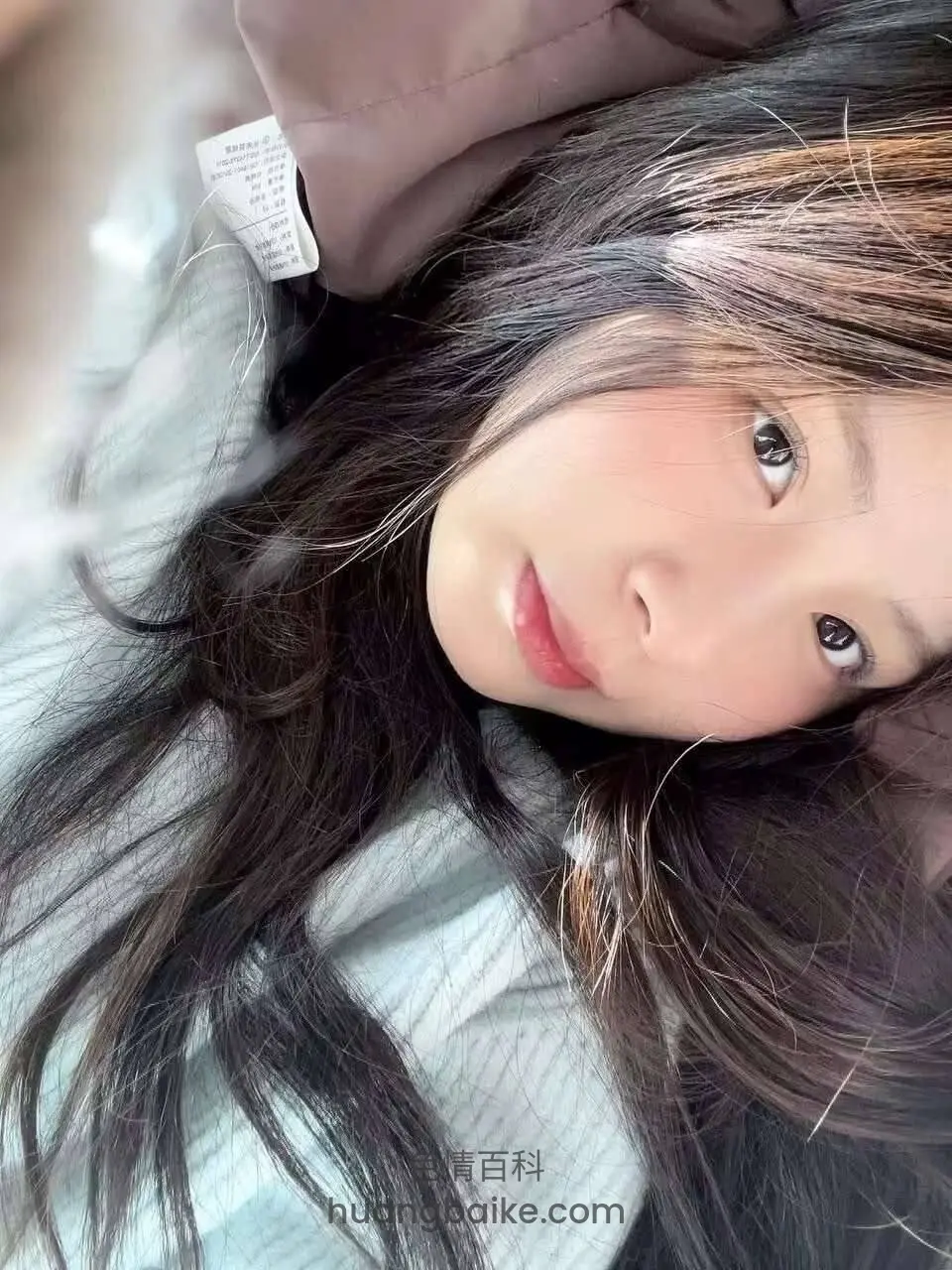 躺着侧头看镜头，枕头有衣服标签