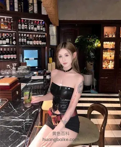 酒吧吧台前坐着，手边一杯鸡尾酒