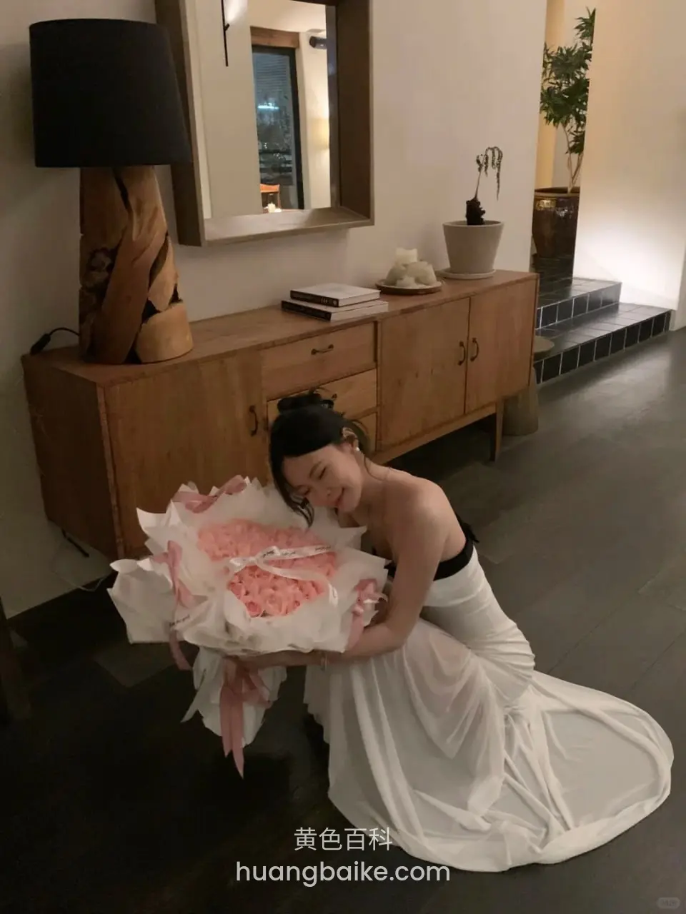 客厅木柜前，抱着粉玫瑰花束
