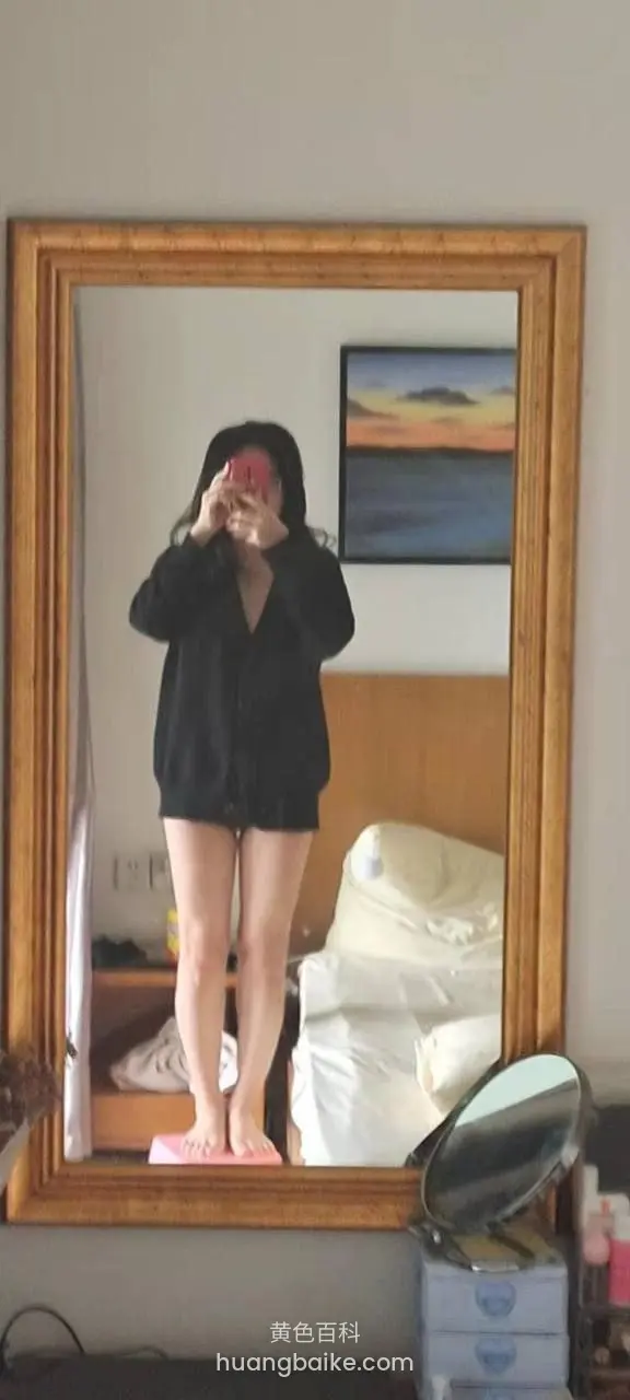卧室大镜子前站立，双手举手机拍摄镜子反射
