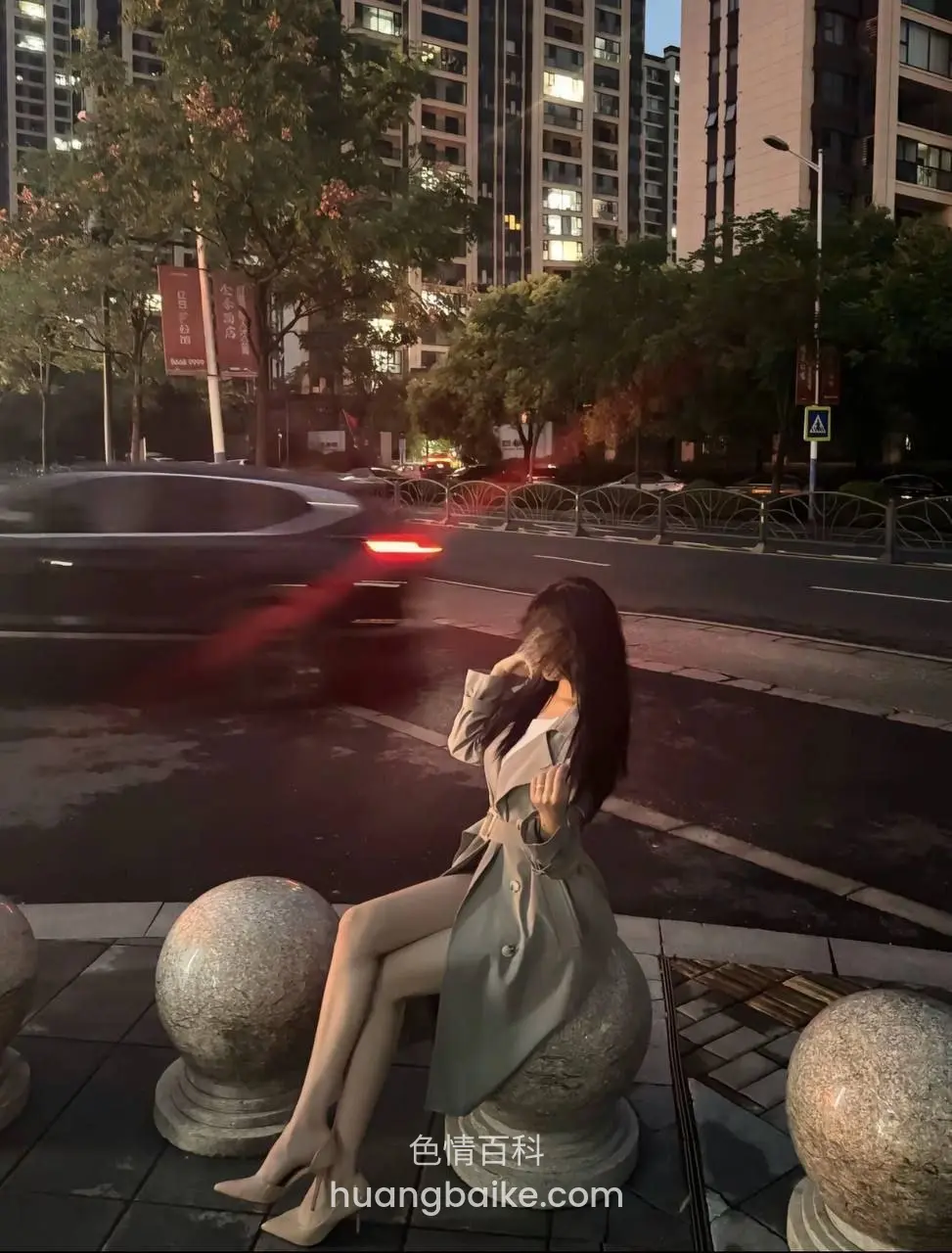路边石墩上坐着，街景车流经过