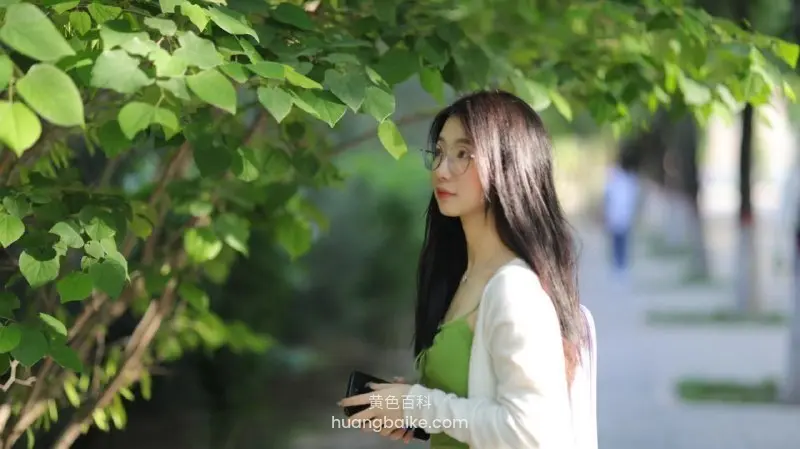 树荫下侧脸的绿衣女孩