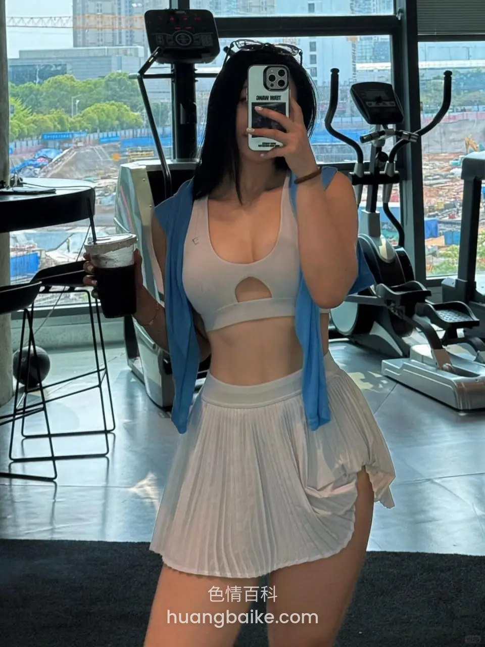 健身房里举着手机自拍，手里拿着咖啡杯