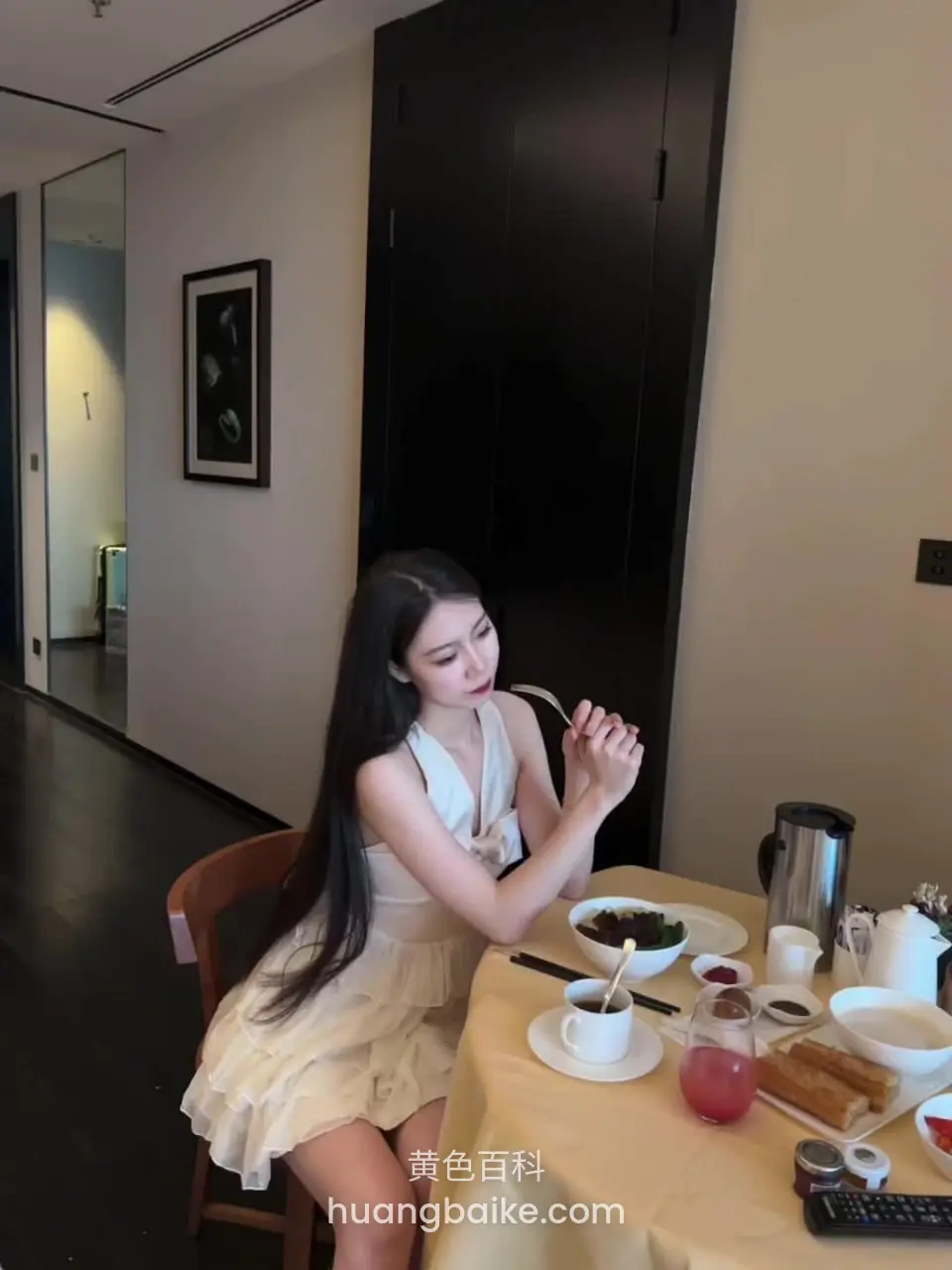 餐厅桌边坐着吃东西长发垂肩