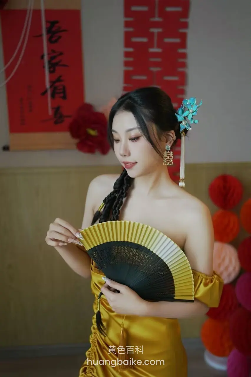 拿着金色扇子低头看