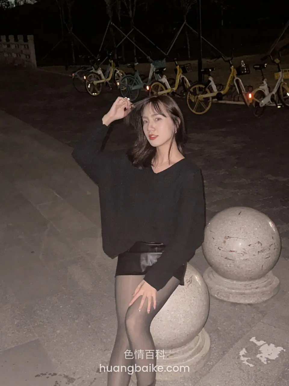 夜里共享单车旁手扶头发
