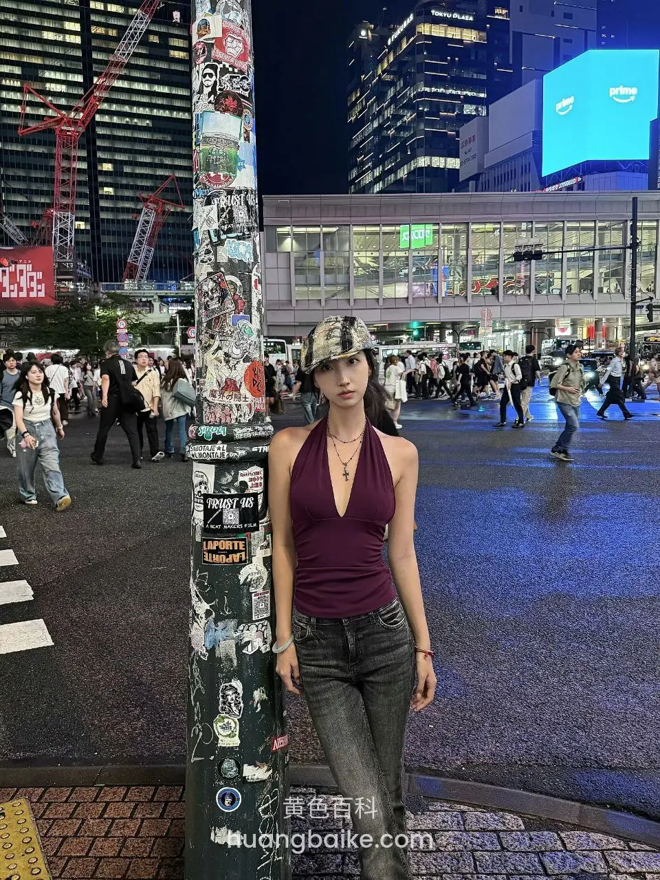 夜间街头贴满海报的柱子旁站立