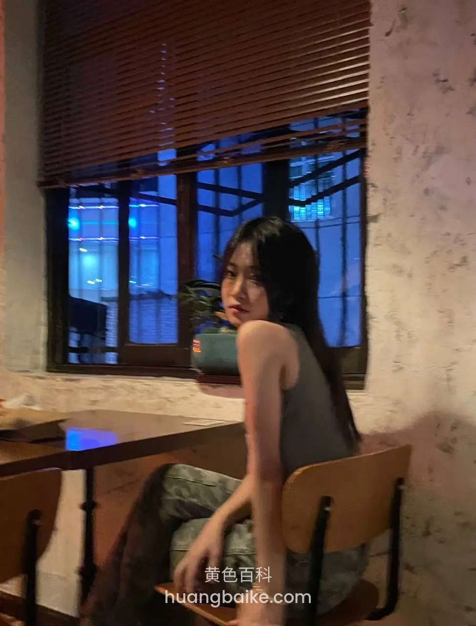 夜间窗边坐着，身后是城市灯光