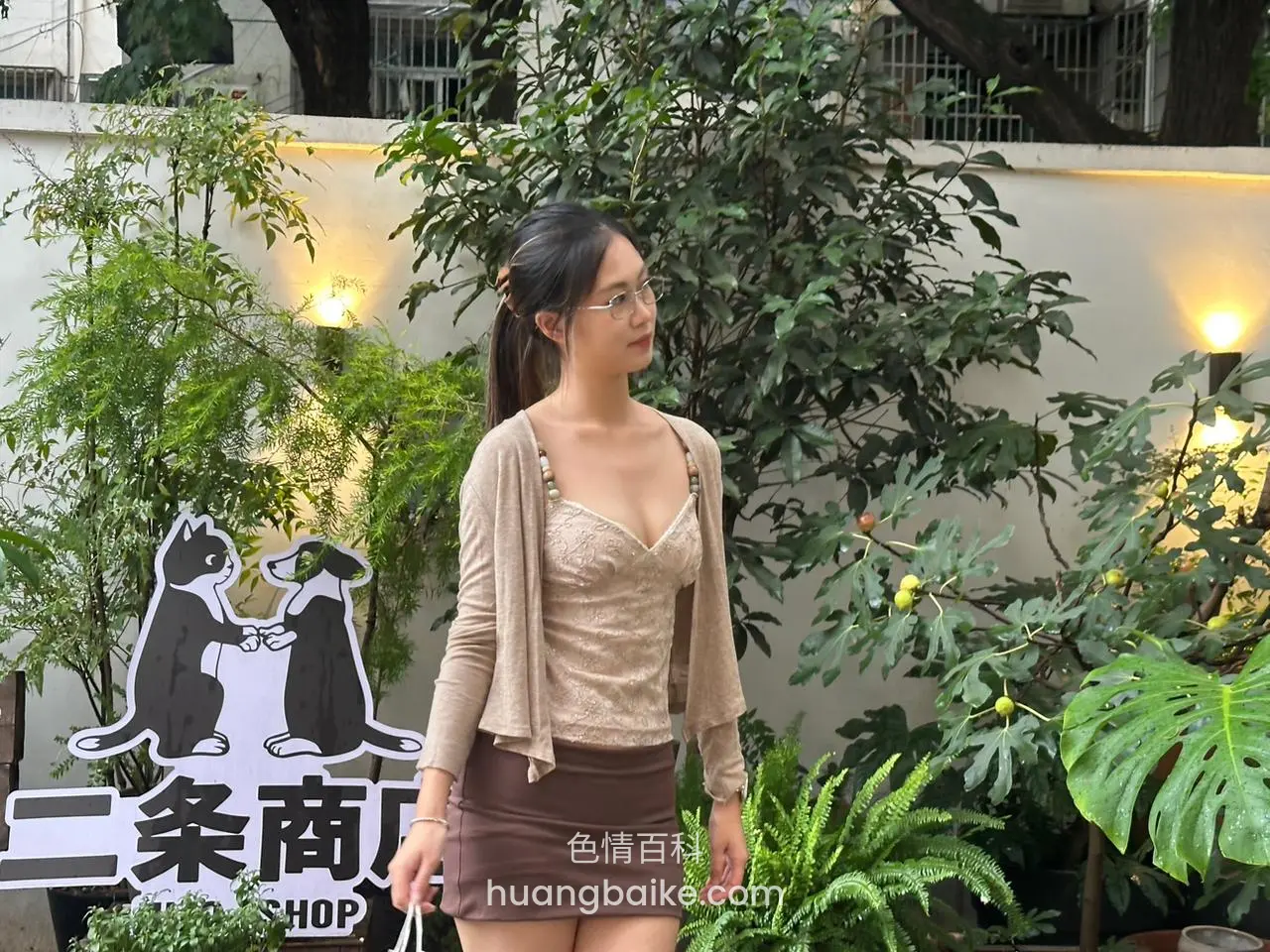 二条商店门口站立，身旁绿植环绕