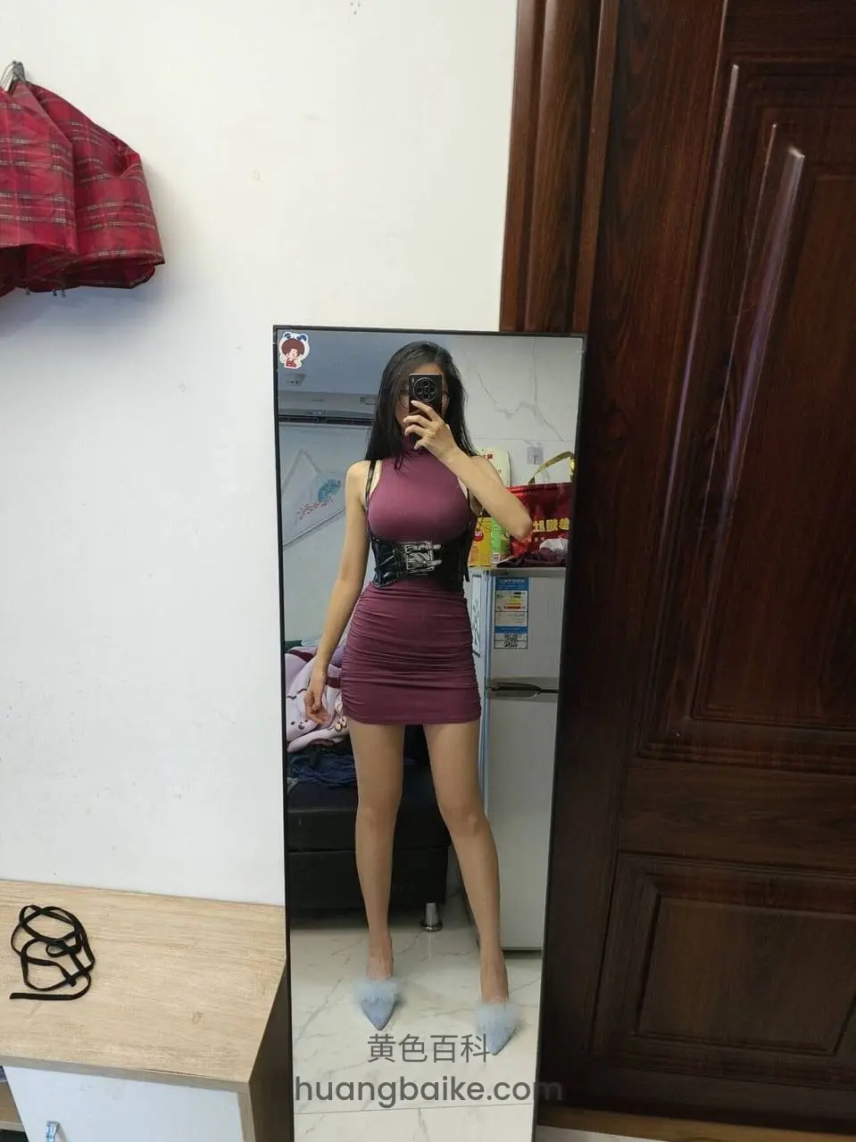 镜子前自拍，手举手机挡脸，身后木门和冰箱