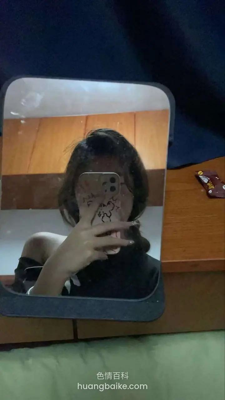 镜子前举手机自拍，手挡住半张脸
