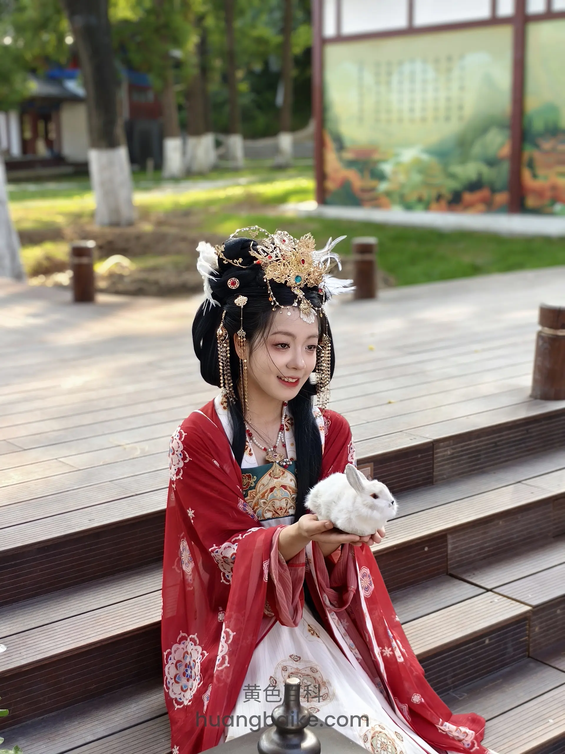 汉服女子坐在木台阶上捧着小白兔