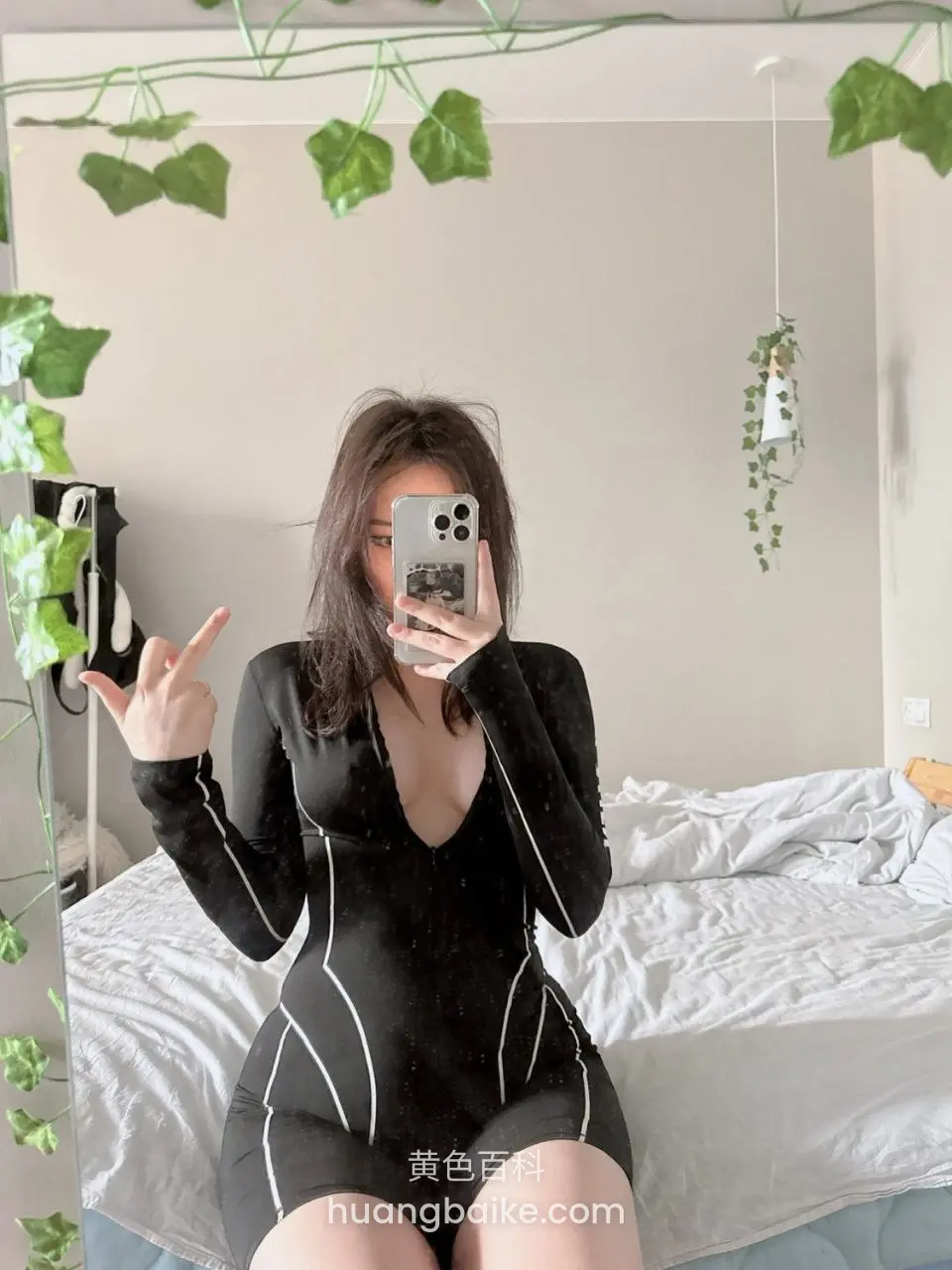 镜子前黑连体衣比耶手机自拍