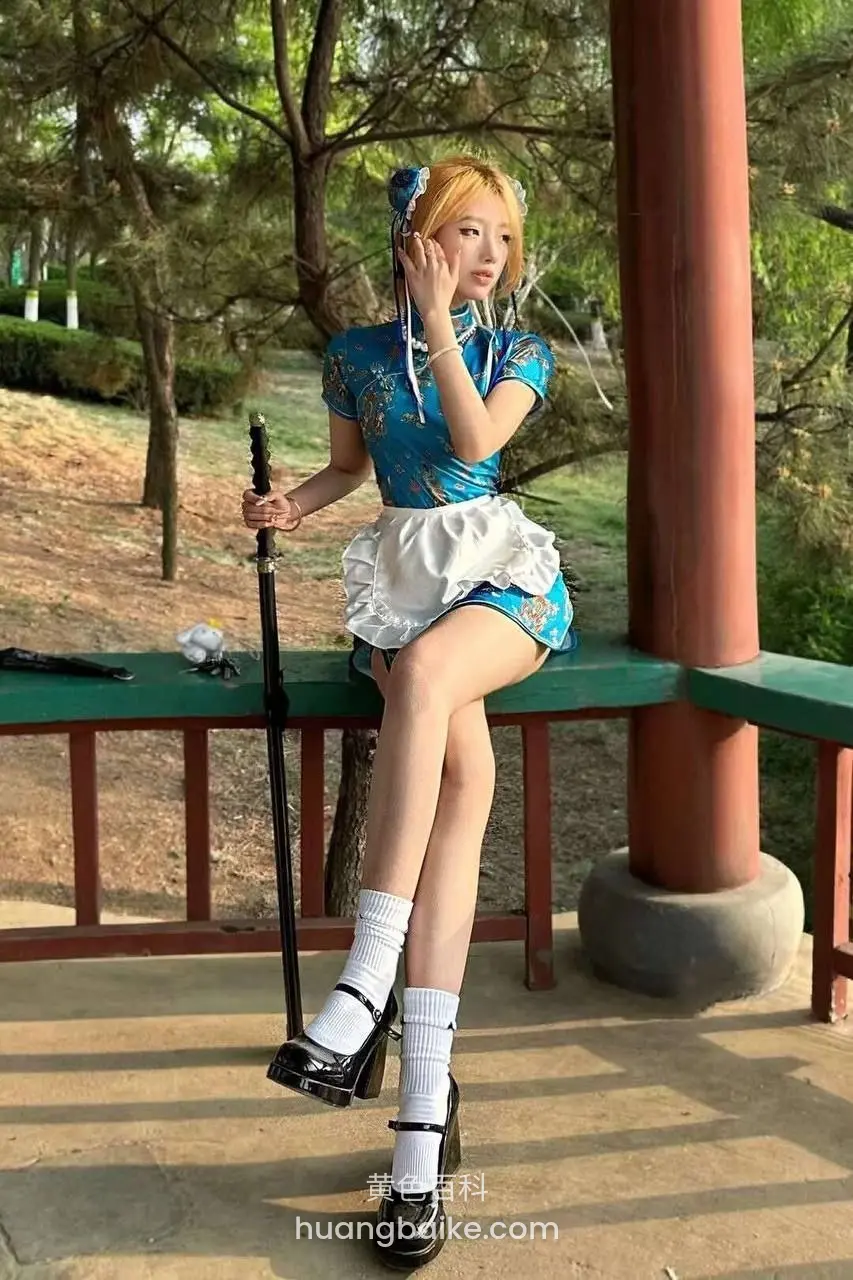 绿栏杆上侧身坐，另一手举到脸旁