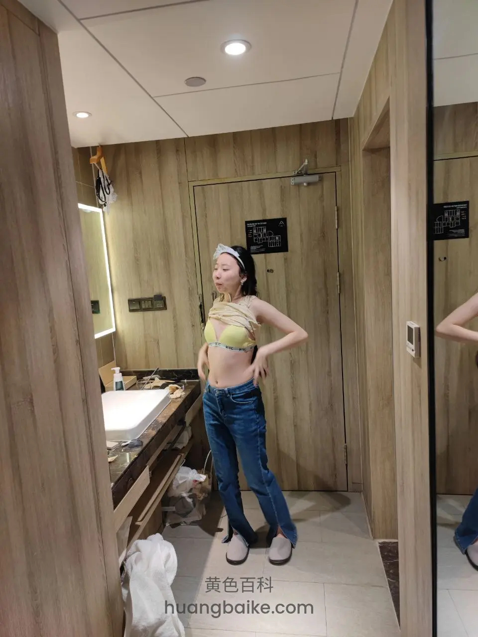 洗手间镜子前站立，双手叉腰对着镜子