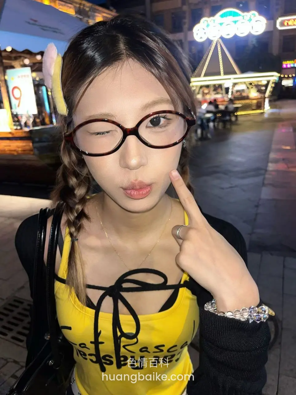 夜市街头wink指脸，身后摩天轮亮灯