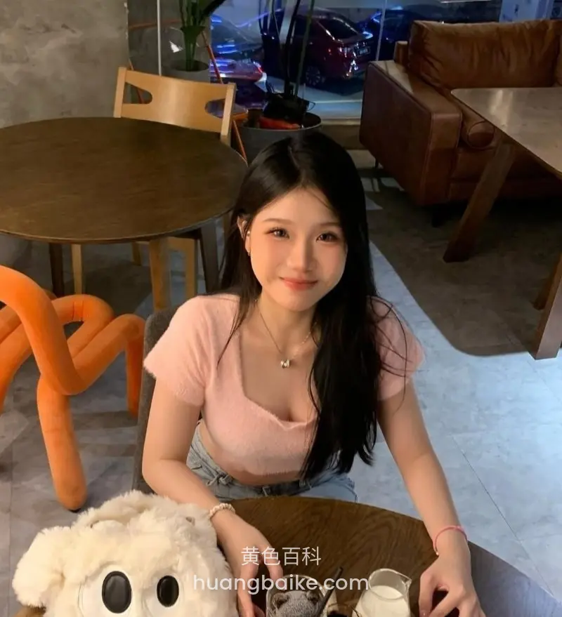 咖啡馆圆桌前手放桌上，桌上白毛绒玩具和玻璃杯