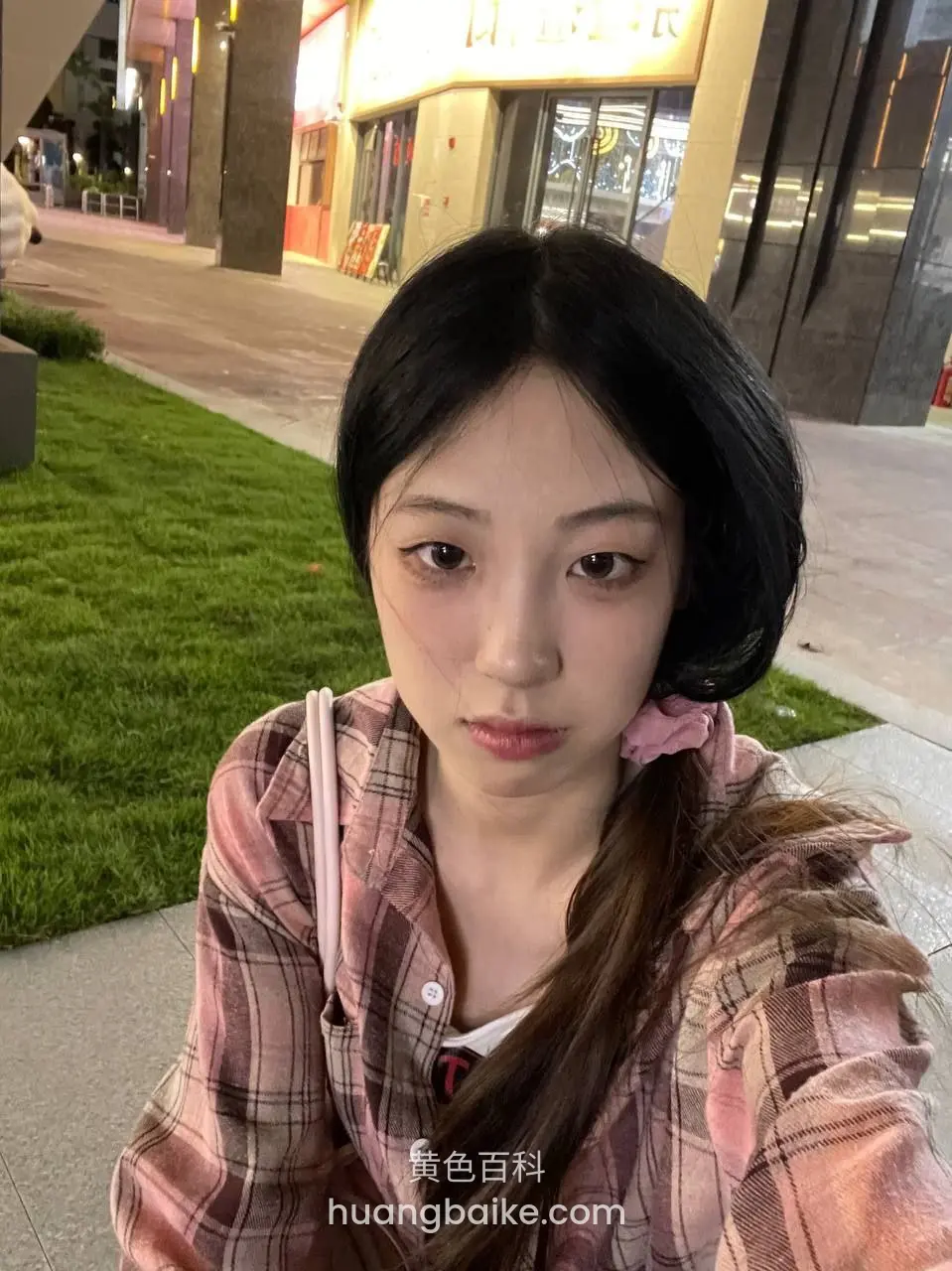 镜头对着身后商场灯光和草坪