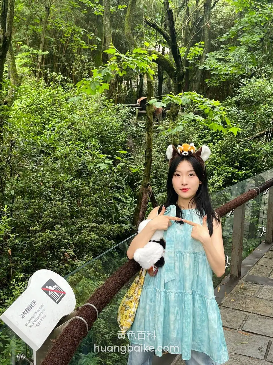 森林木栈道上，镜头对着身后树木和指示牌
