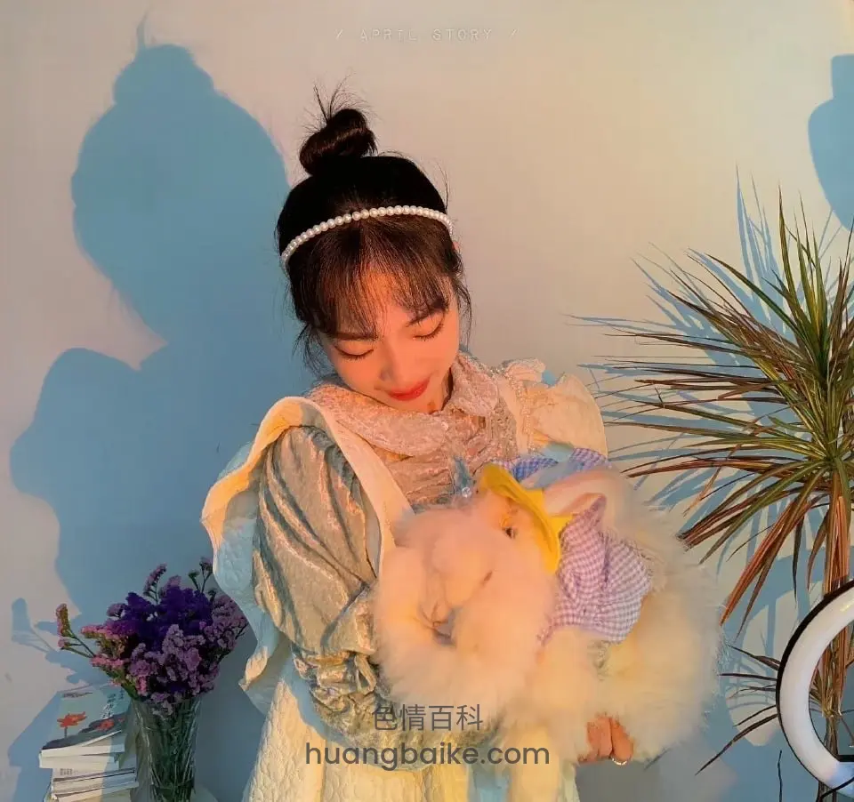 抱着穿衣服兔子玩偶，墙上投影和绿植环绕