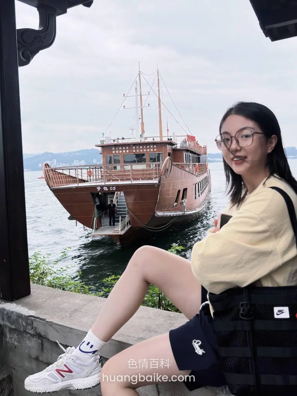 码头边石墩上坐着，黑包斜跨肩