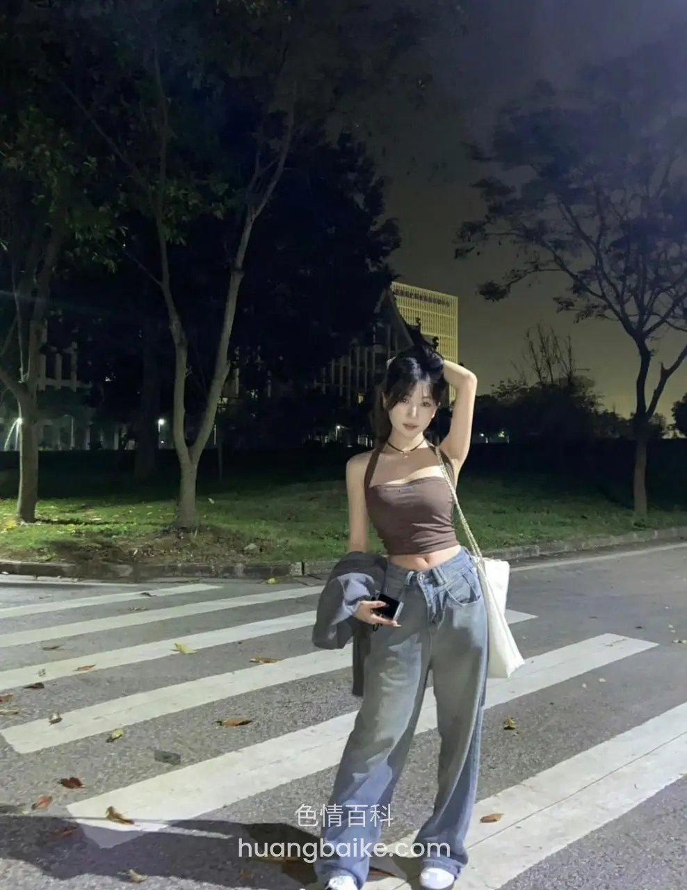 夜间斑马线站立，一手举过头顶