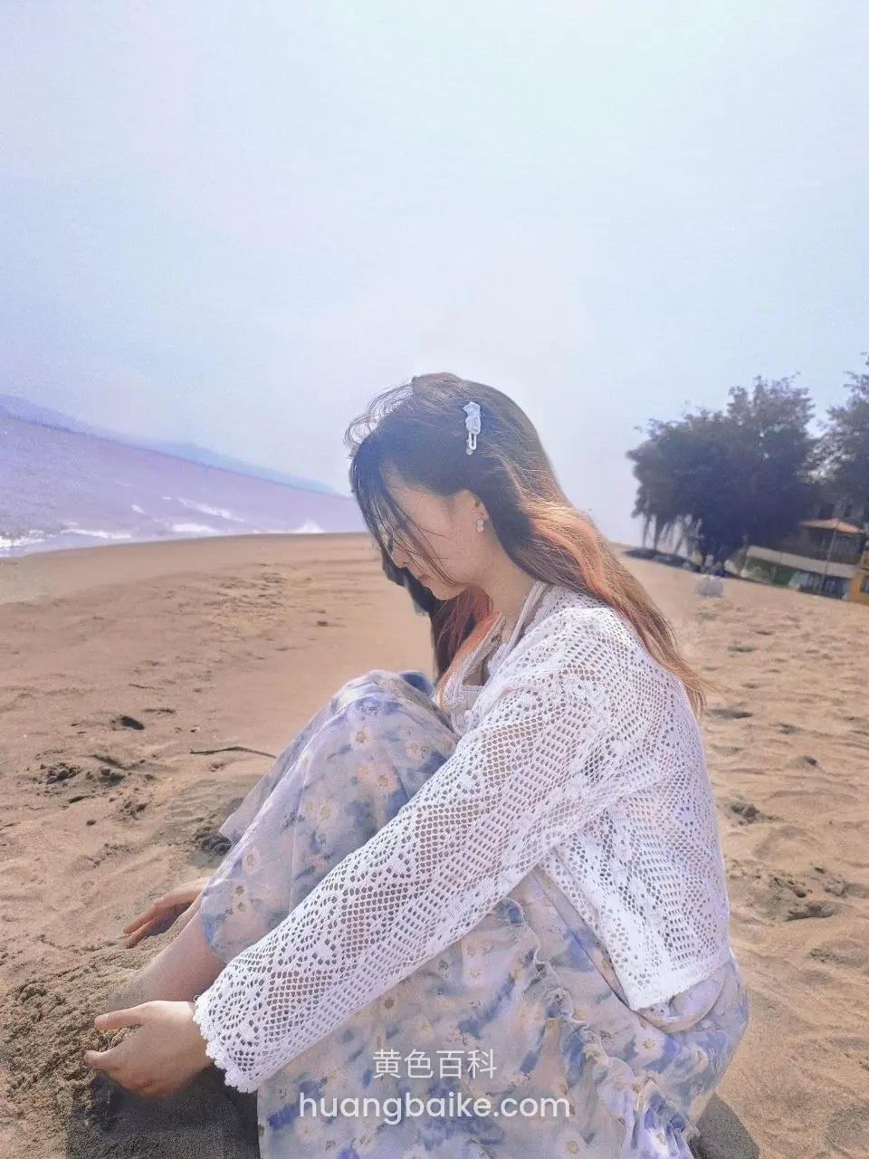 沙滩上坐着玩沙子