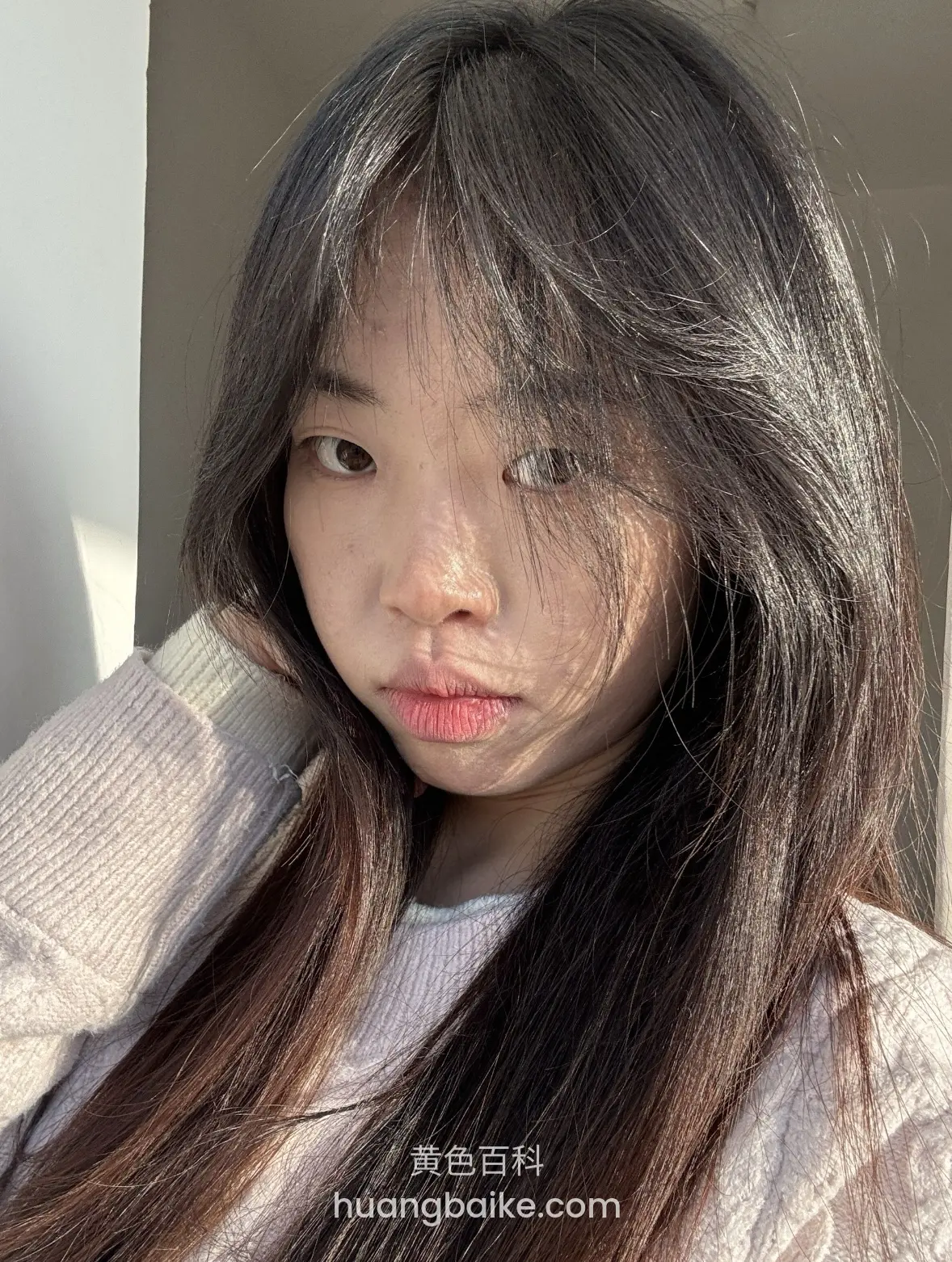 白毛衣下手撑着下巴，阳光照在脸上