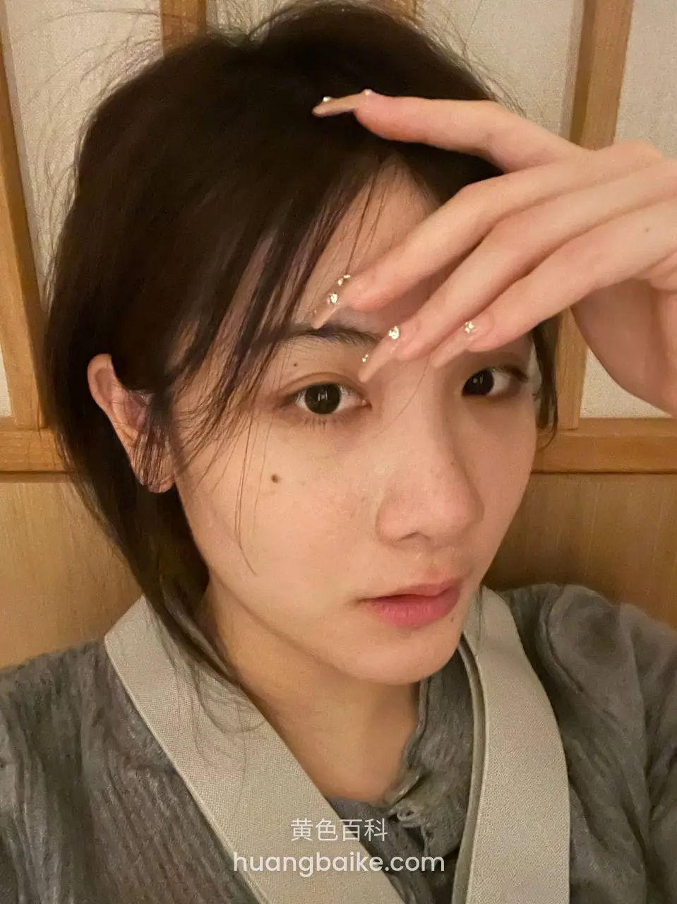 手举额头自拍，眼睛看向镜头