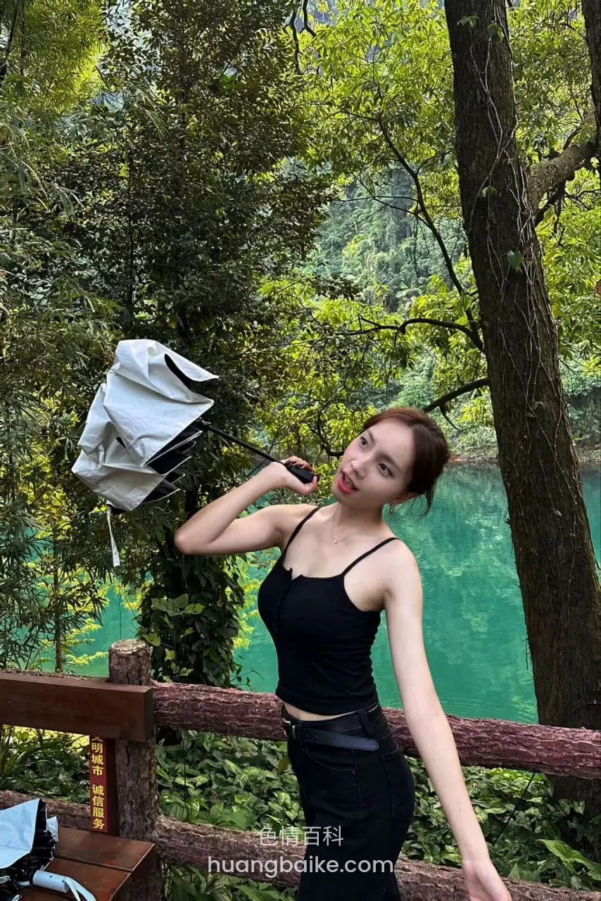 森林湖边木栏杆前举着白伞