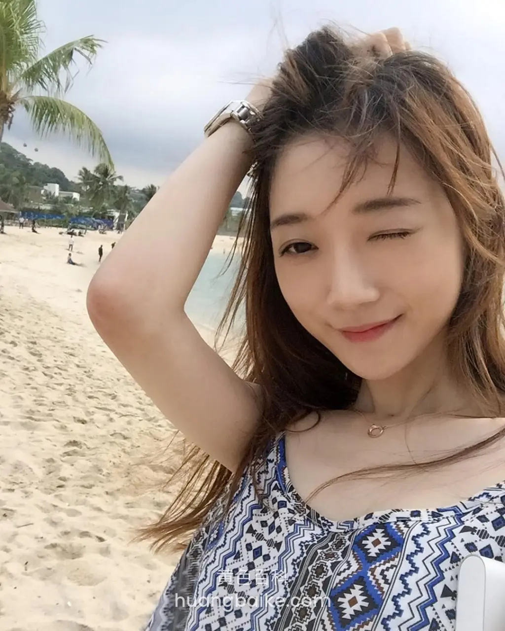 沙滩上单手托着头发自拍，身后是椰子树和海