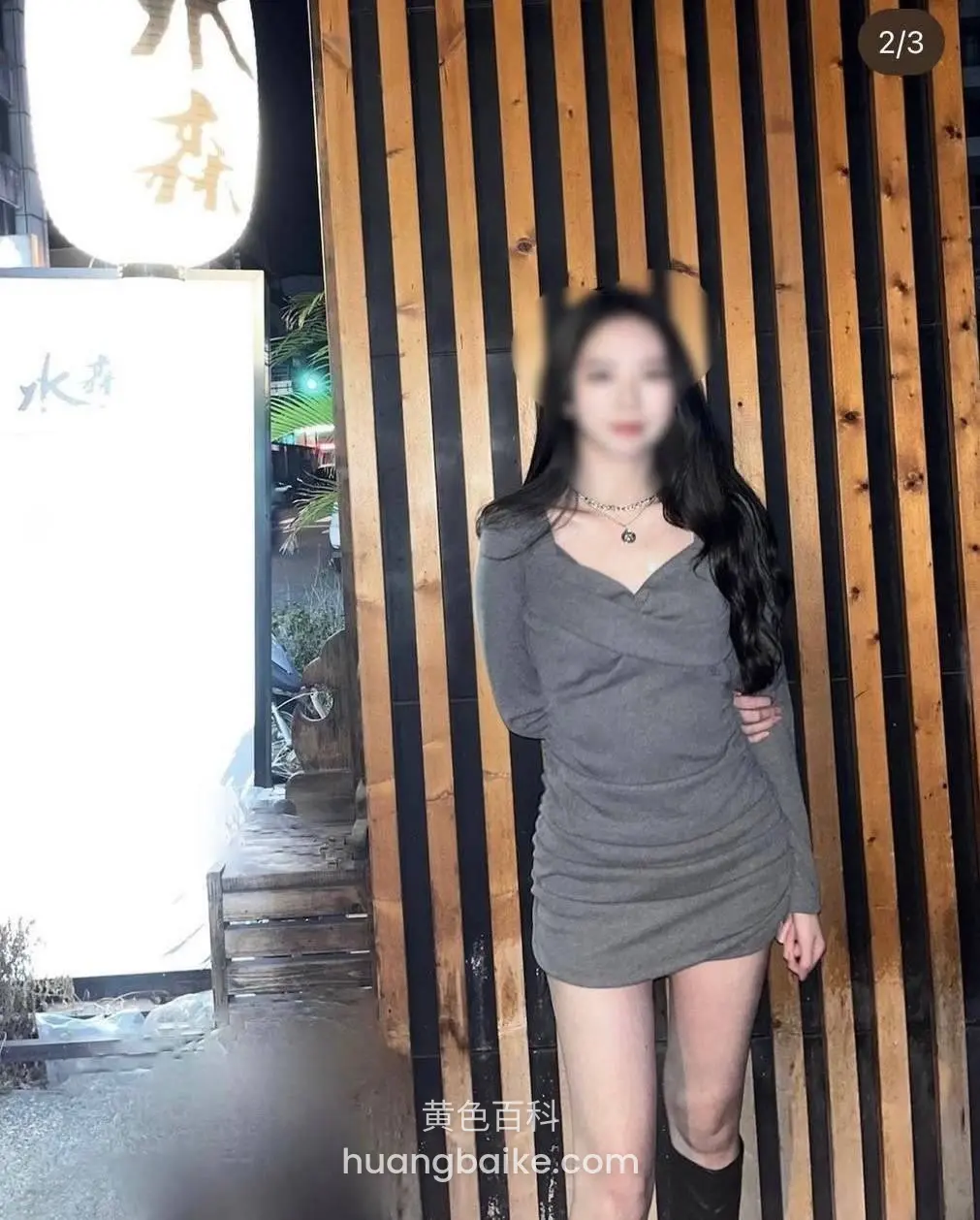 店门口木板墙前站立，灯笼写着水森