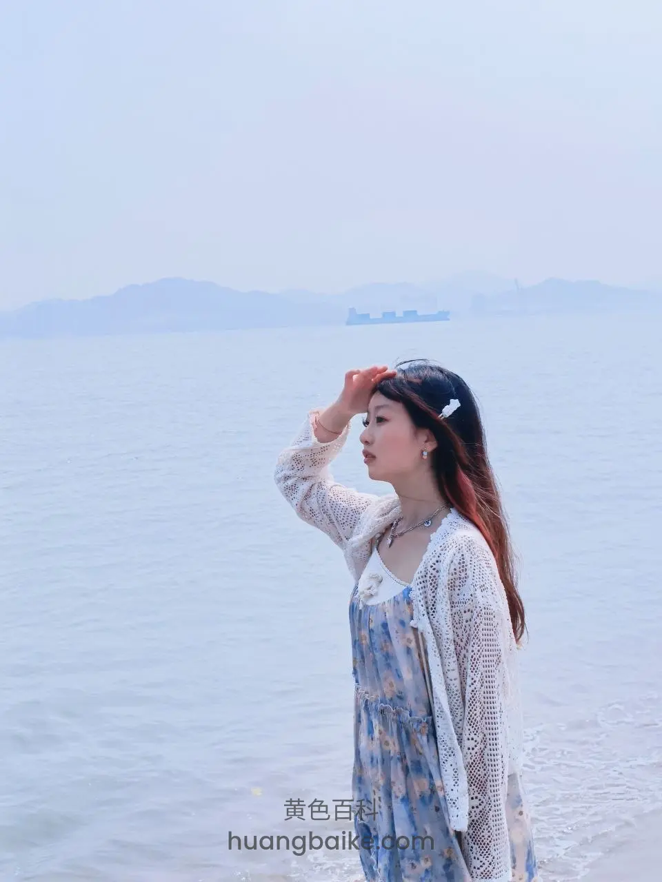 海边水里举手遮阳看远处船