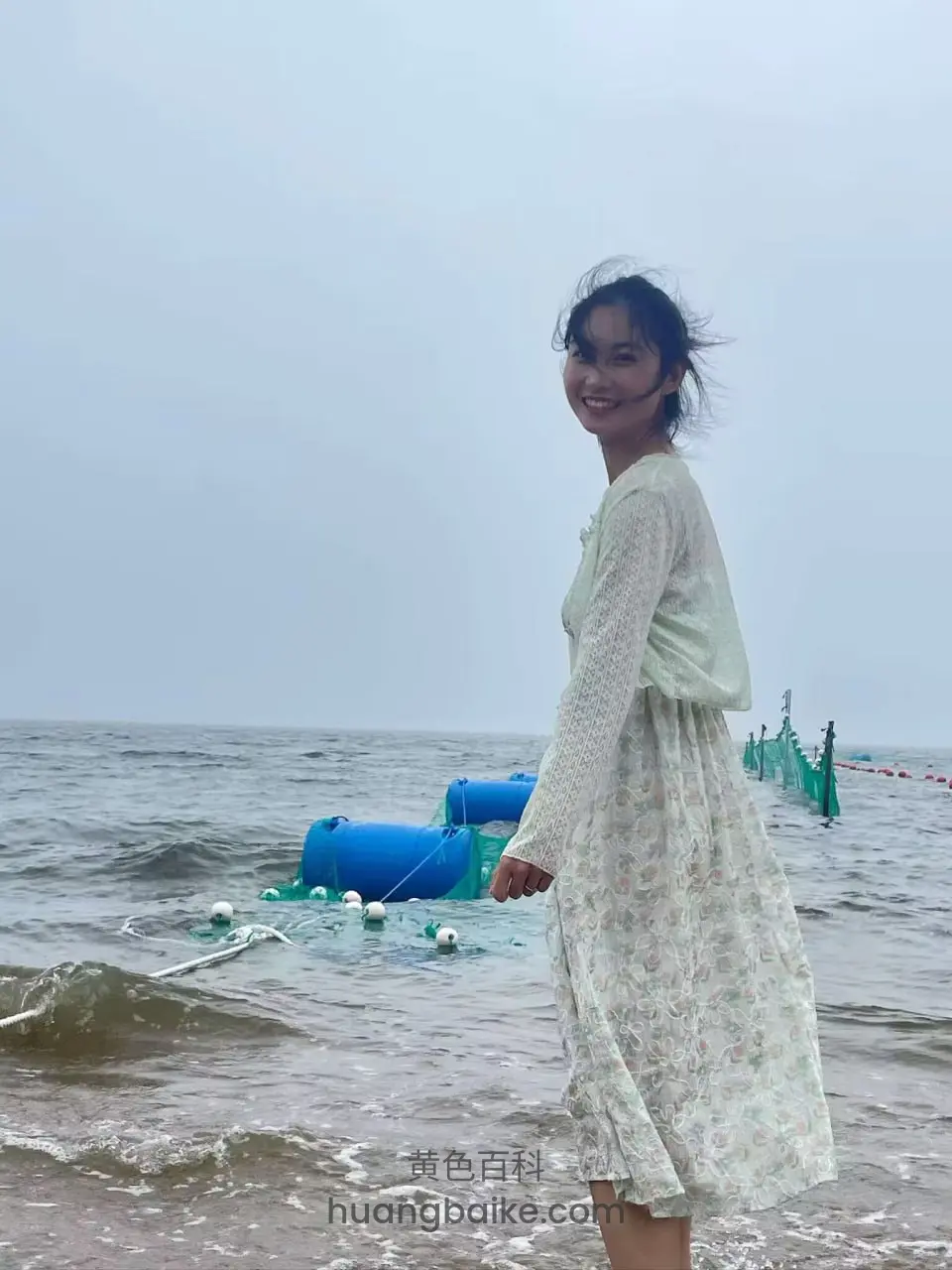 海边回头看镜头，身后蓝色浮筒