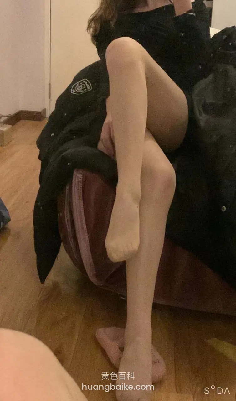 房间地板上，腿搭在红凳